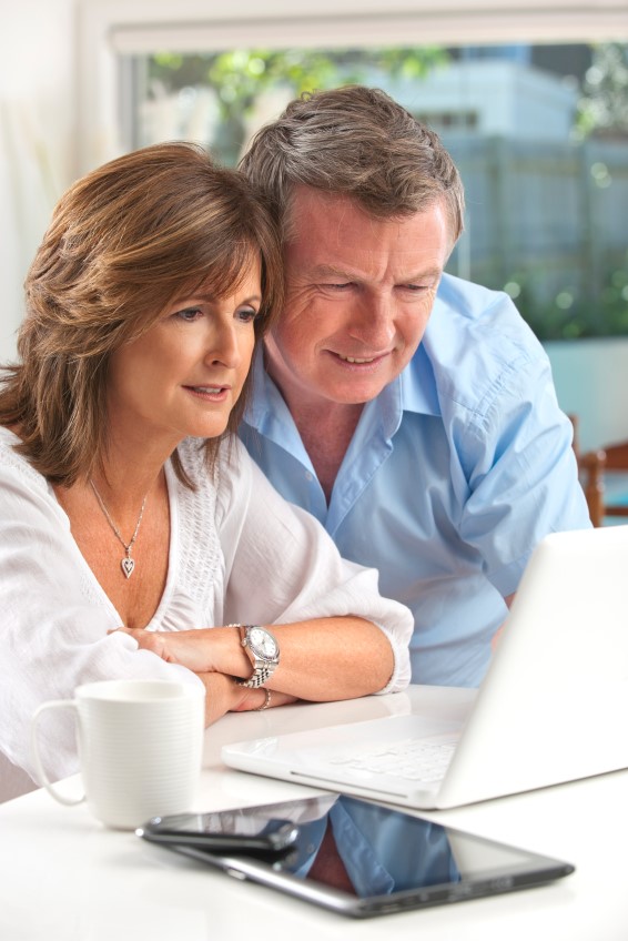 man and woman reading laptop computer screen