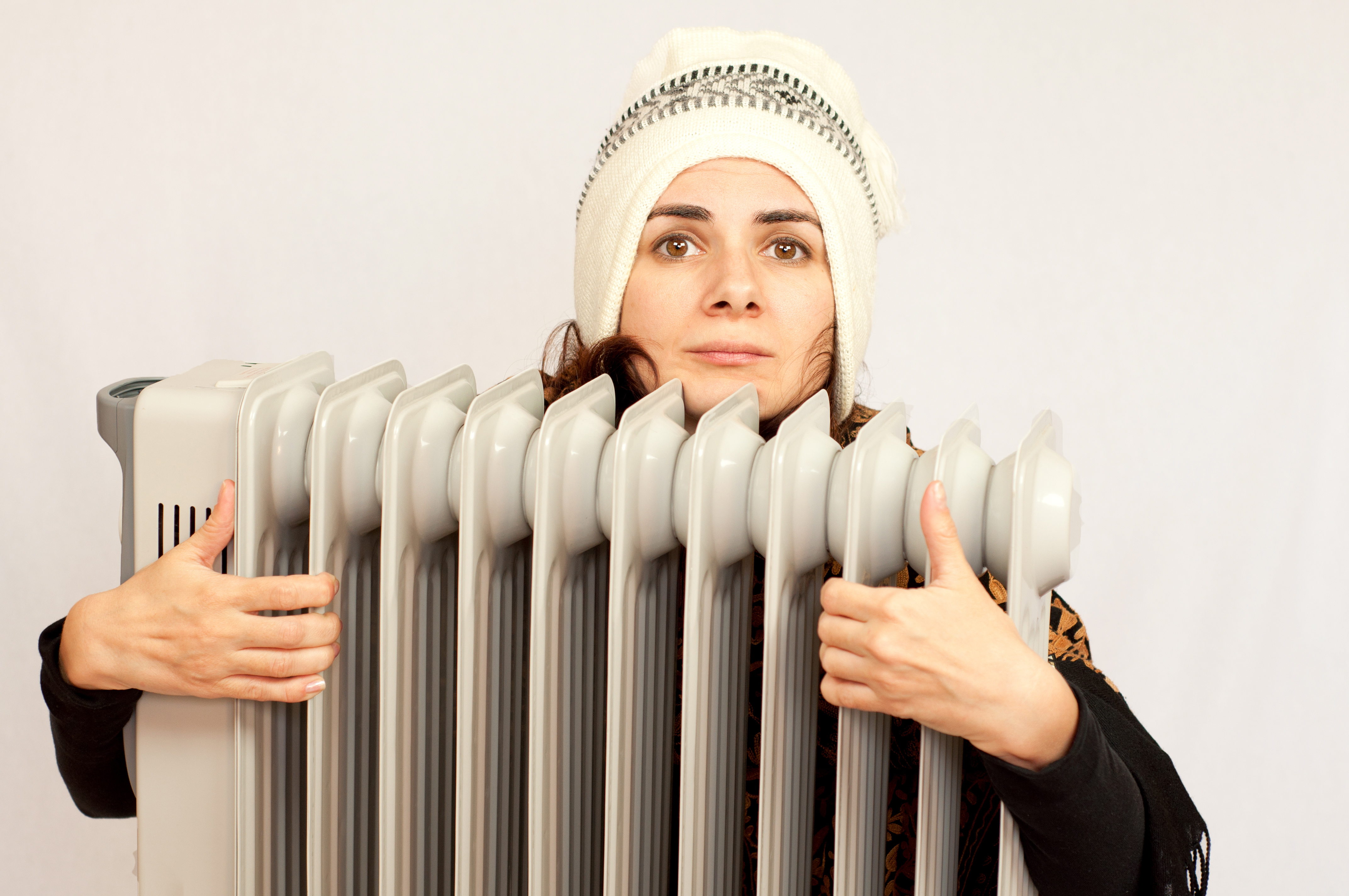Young woman holding an electric heater