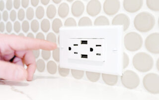 hand pointing to USB-enabled outlets