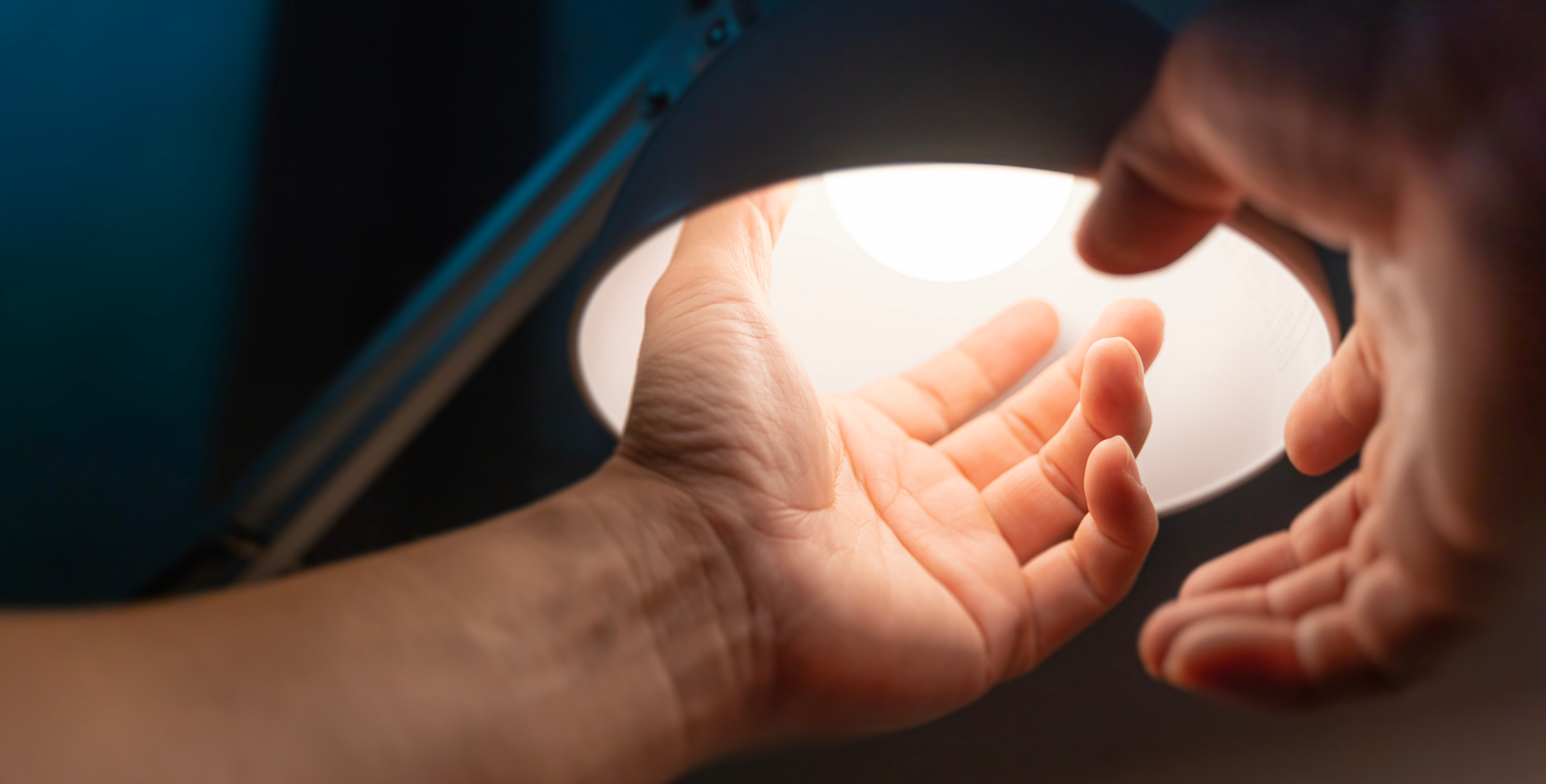 hands changing out a light bulb
