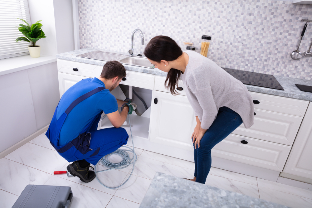 Plumber clearing a kitchen drain